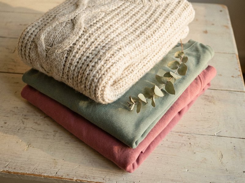 adhd capsule wardrobe — soft knitted fabric folded on a pale wooden surface, lacedopamine.com