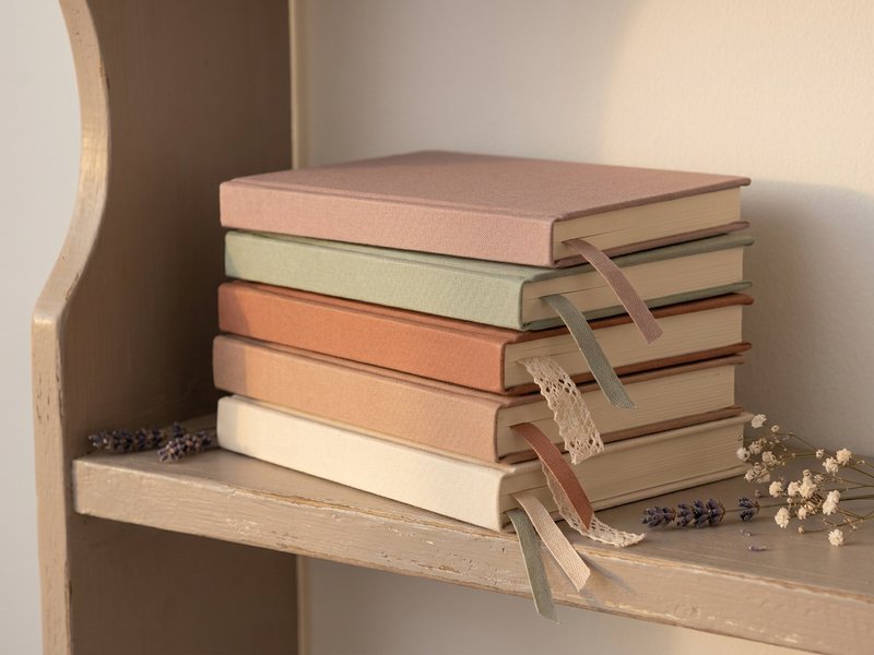 adhd diagnosis at 30 — a stack of closed planners with plain covers on a shelf, lacedopamine.com