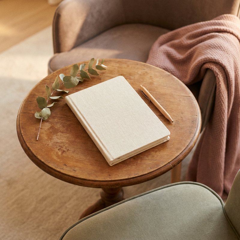 adhd in relationships — a shared notebook and pen on a table between two chairs, lacedopamine.com