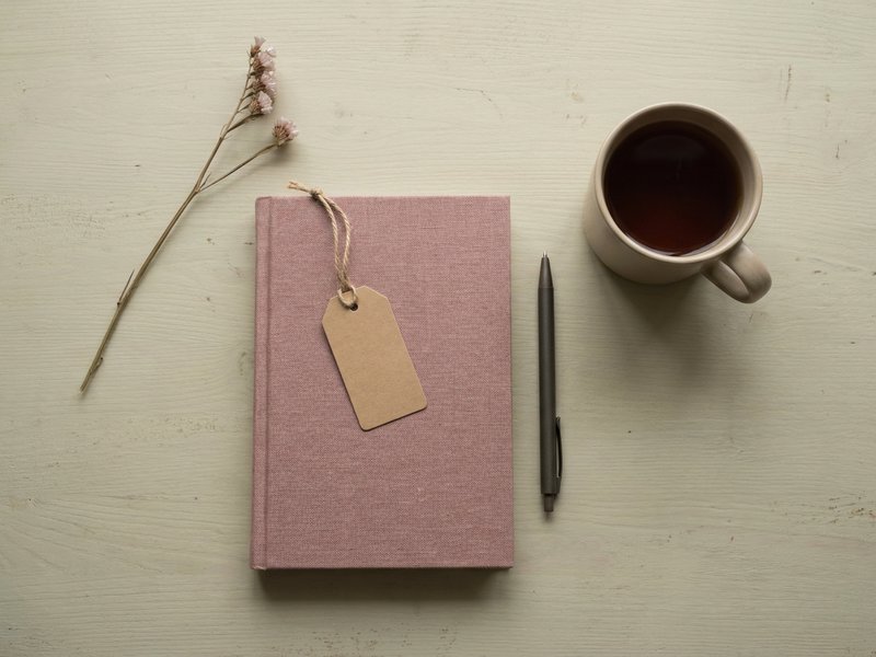 adhd paralysis — a still desk with an unopened notebook and cold tea, lacedopamine.com