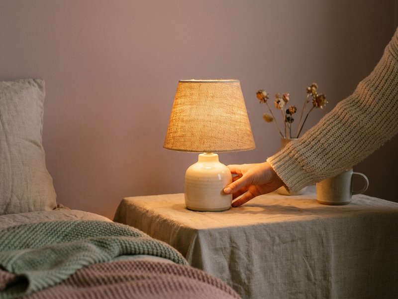 aesthetic nightstand ADHD — a warm dimmable lamp on a linen nightstand at dusk, lacedopamine.com