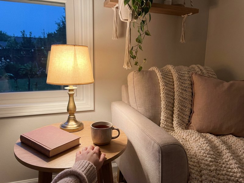 warm autumn corner for fall room refresh ADHD, lamp and knit throw beside a linen chair, lacedopamine.com