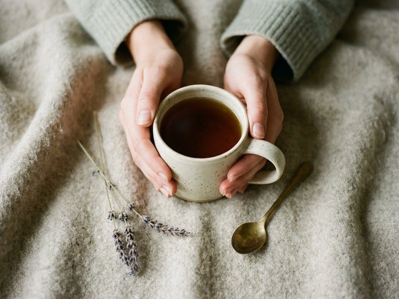 warm drink and blanket for fall self care ADHD, cream mug on a wool throw in low autumn light, lacedopamine.com