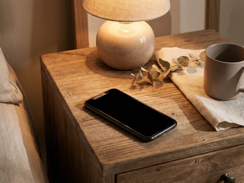 habit stacking ADHD — a phone alarm set on a nightstand in soft morning light, lacedopamine.com