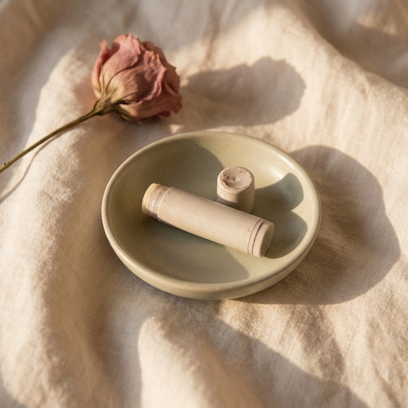 late diagnosed adhd women — a small dish holding a used lip balm on a linen surface, lacedopamine.com