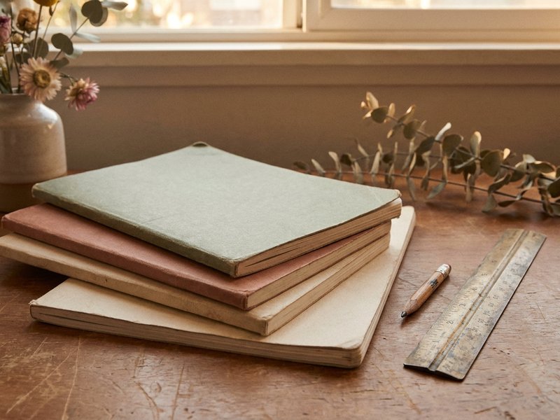 late diagnosed adhd women — a stack of old exercise books with blank covers, lacedopamine.com