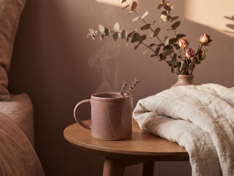 ADHD bedroom setup sleep — a cooling cup of tea set aside on a bedside table, lacedopamine.com
