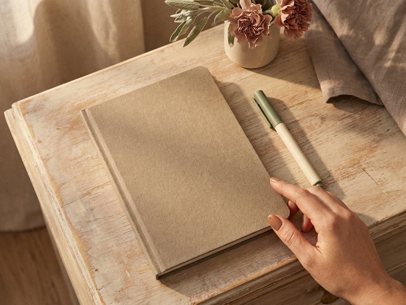 myths about ADHD in women — a closed notebook and pen on a desk, lacedopamine.com