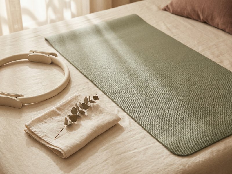 yoga vs pilates ADHD — a Pilates mat and resistance ring laid out for a home workout, lacedopamine.com